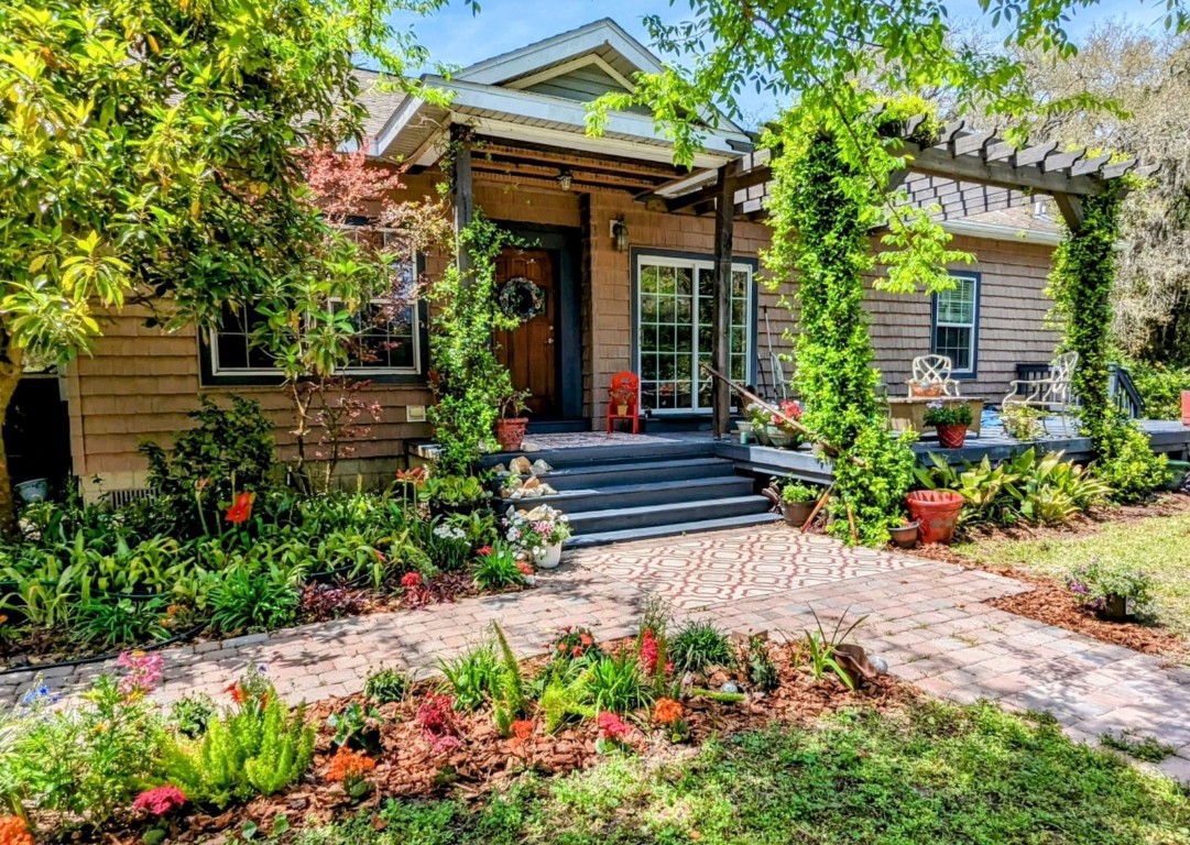 a view of a house with wooden walls and flower plants