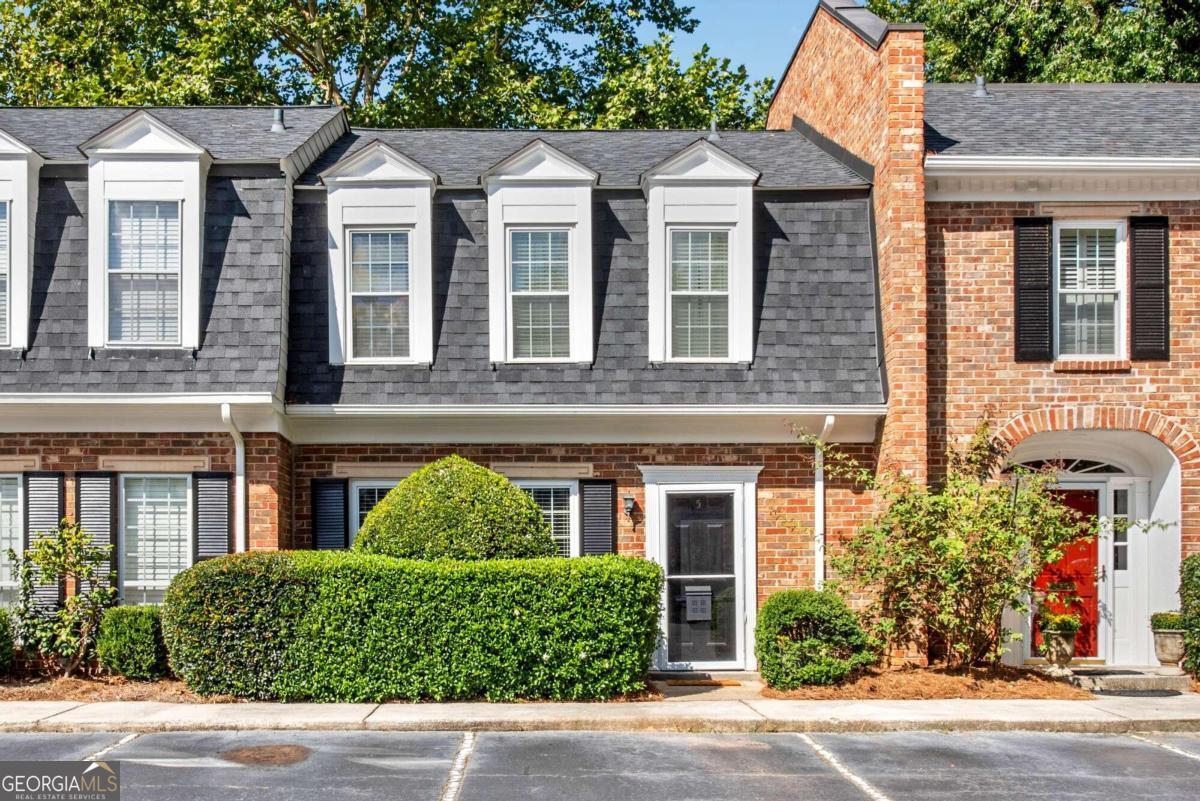 front view of a brick house with a yard