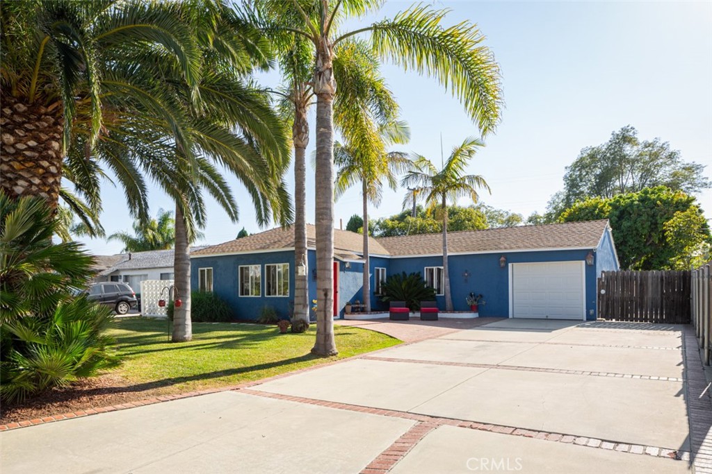 a view of yellow house with palm trees