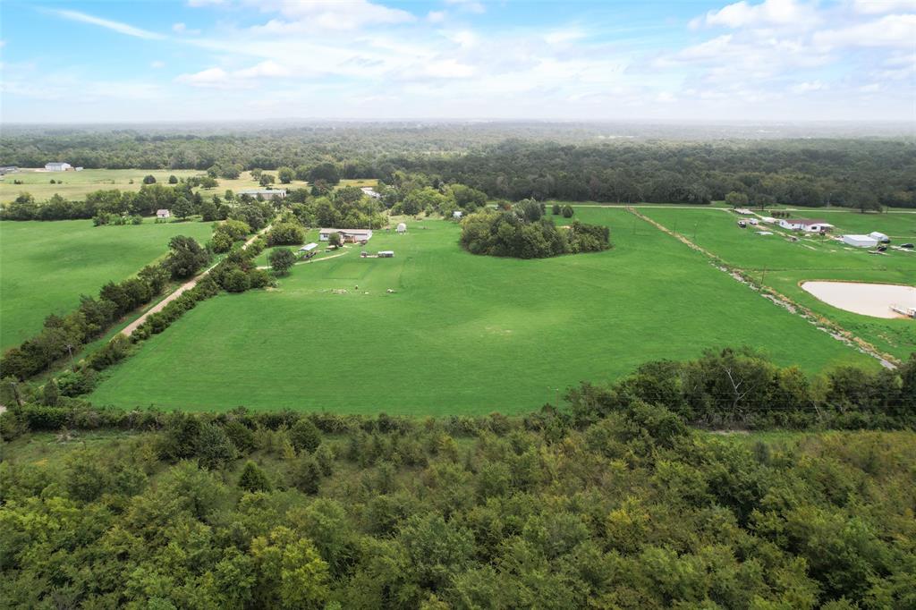 an aerial view of huge green field with lots of green space