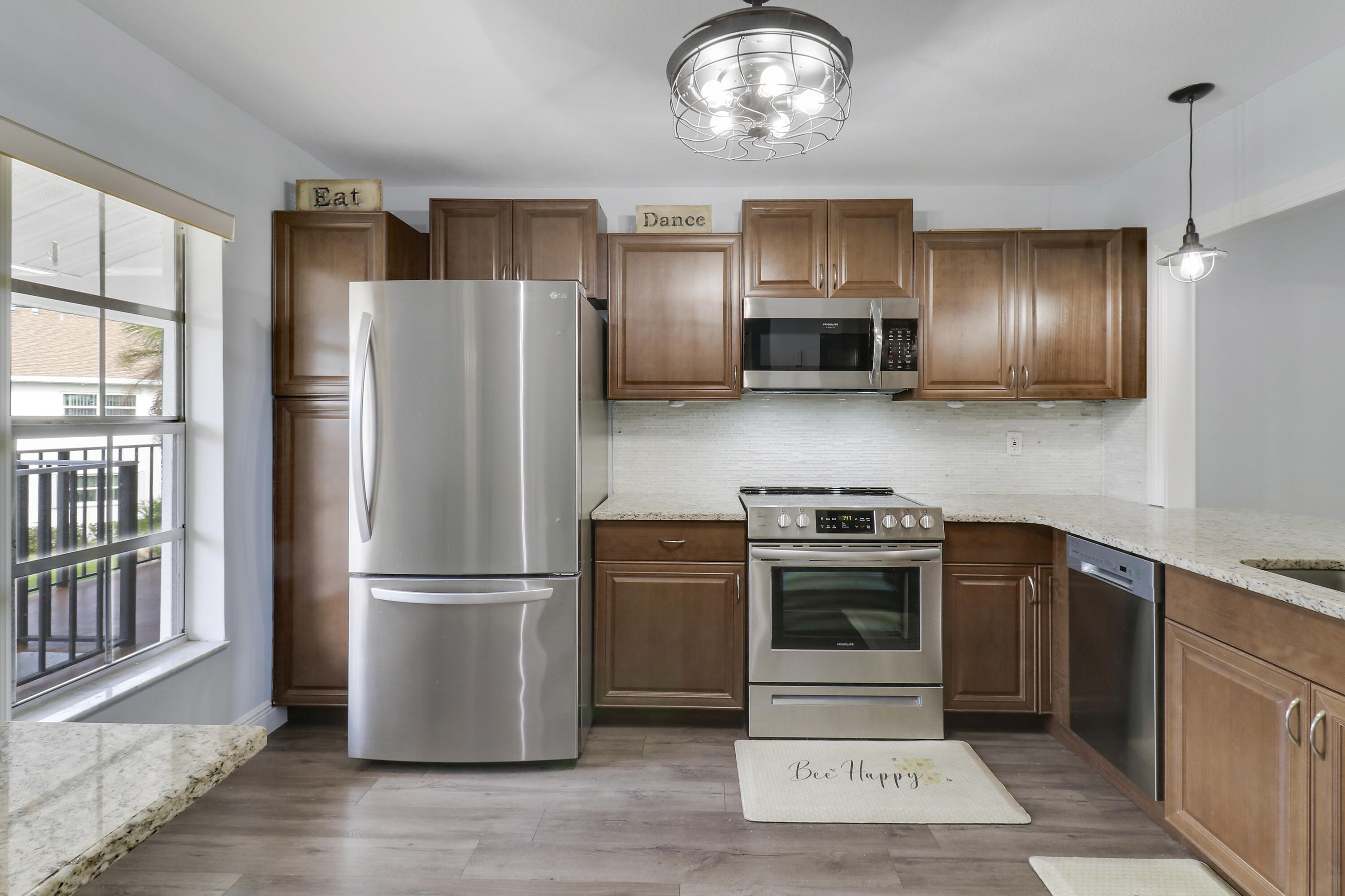 a kitchen with stainless steel appliances granite countertop a refrigerator stove and sink