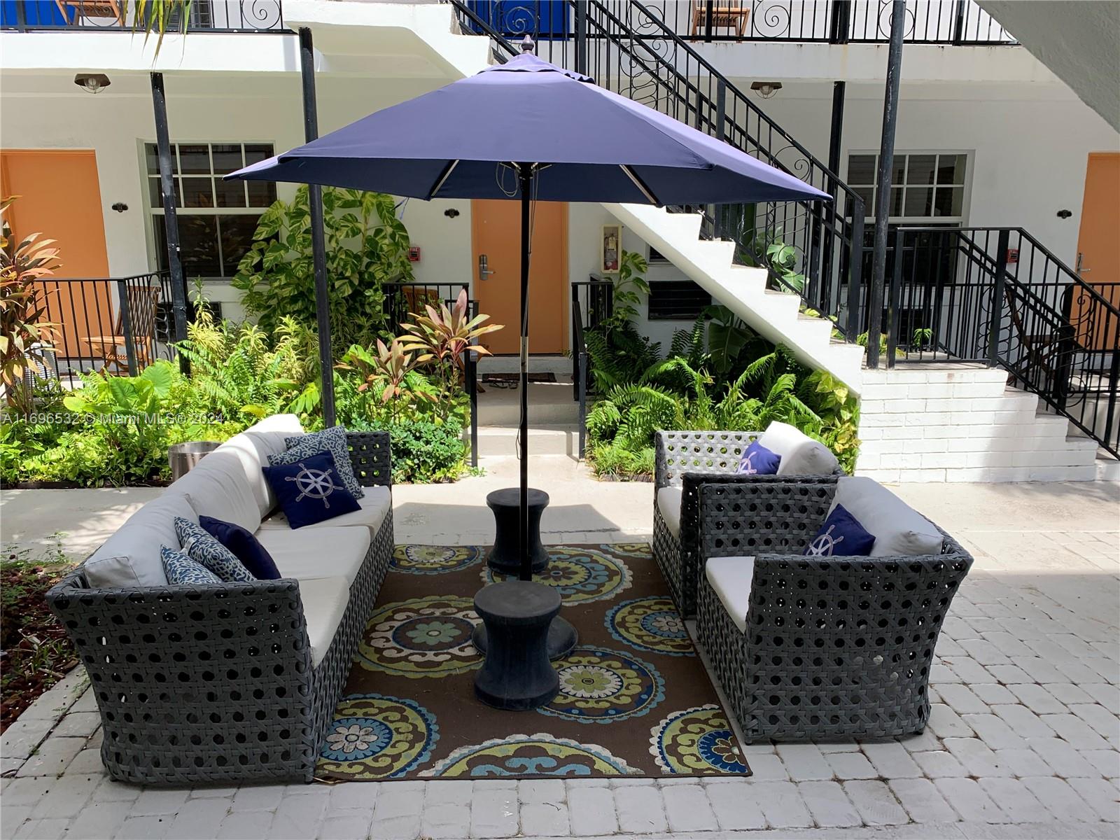 a view of a couches and dinning table with potted plants