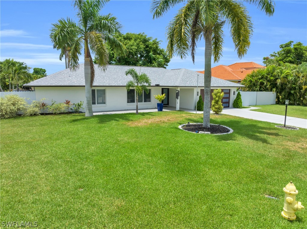 a house that has a big yard with palm trees