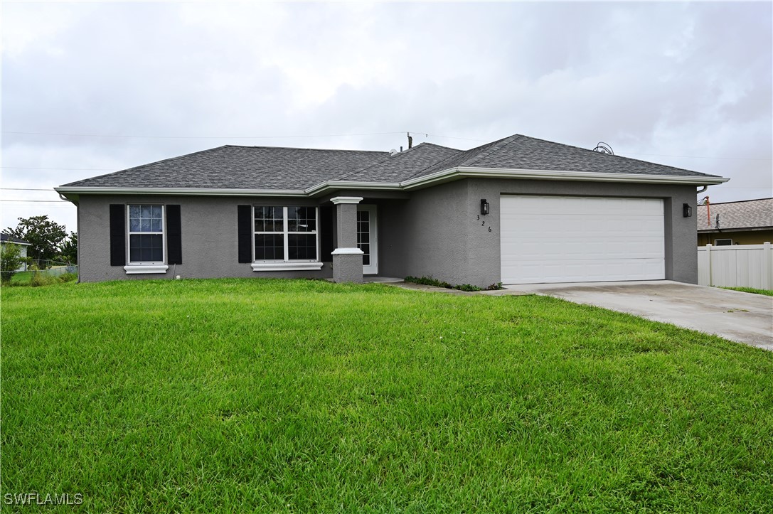 a front view of a house with a yard and garage