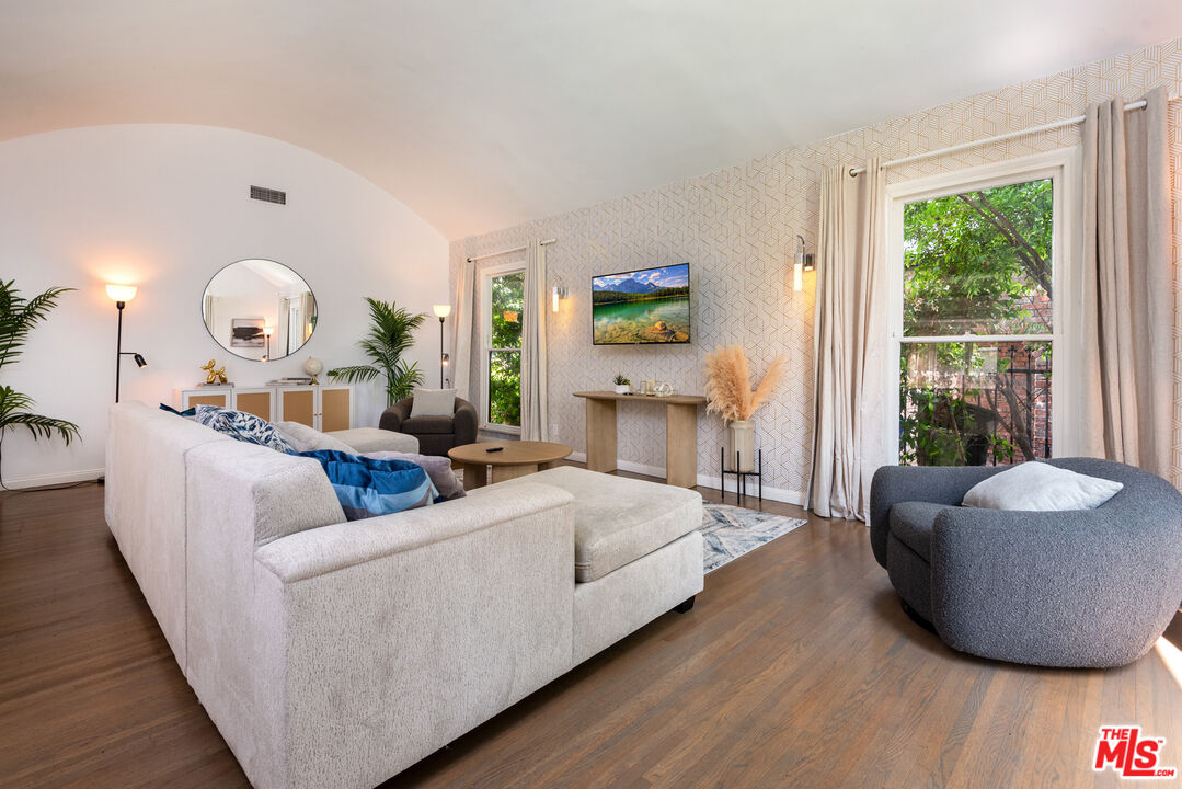 a living room with fireplace furniture and a large window