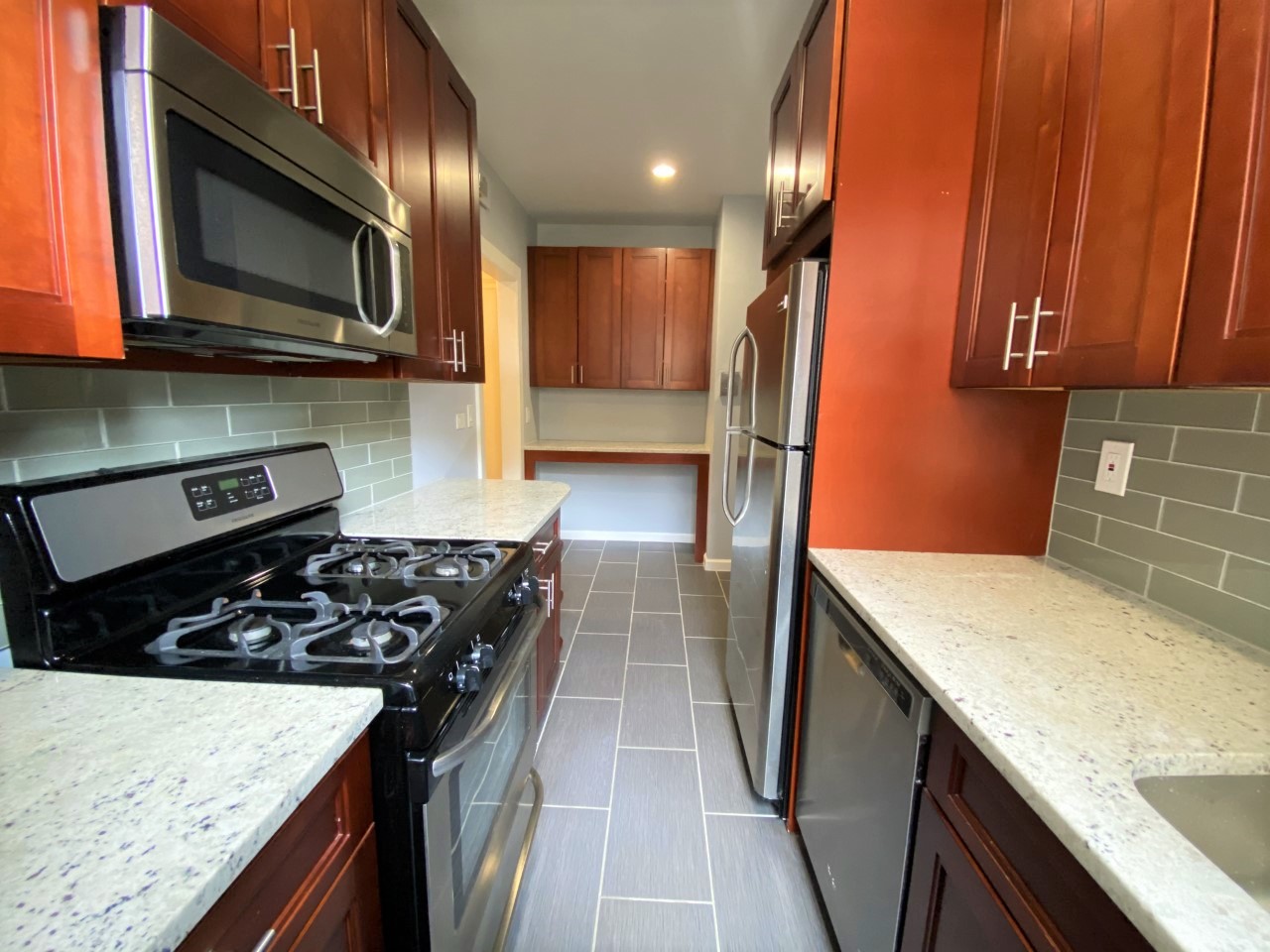 a kitchen with stainless steel appliances granite countertop a stove microwave and sink