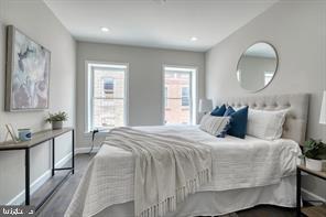 a bedroom with a bed and a large mirror with wooden floor