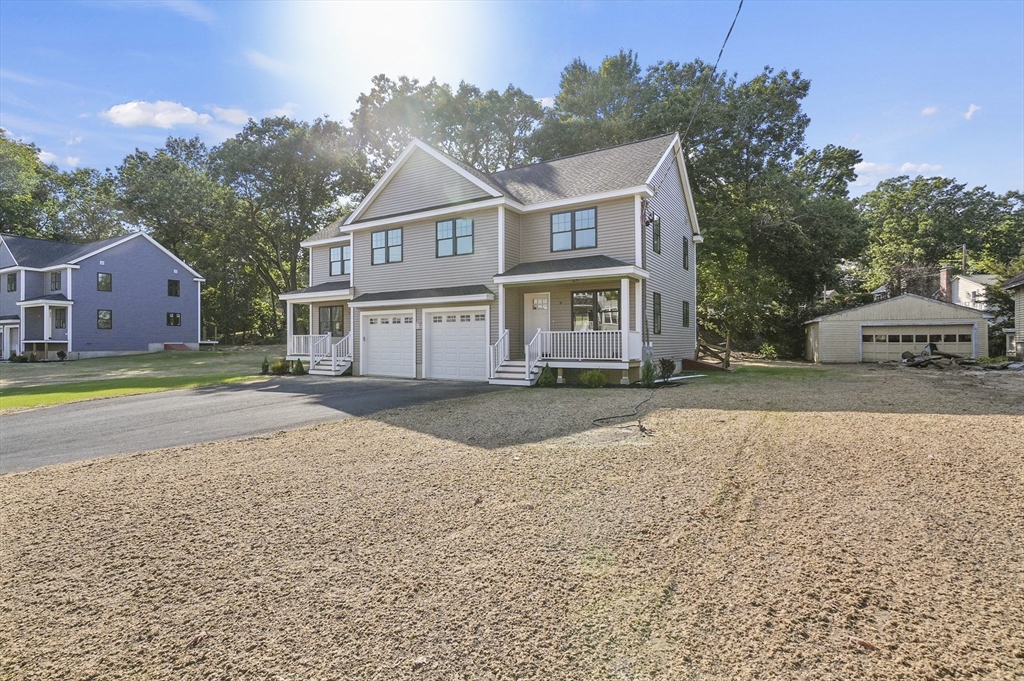 a front view of a house with a yard and trees