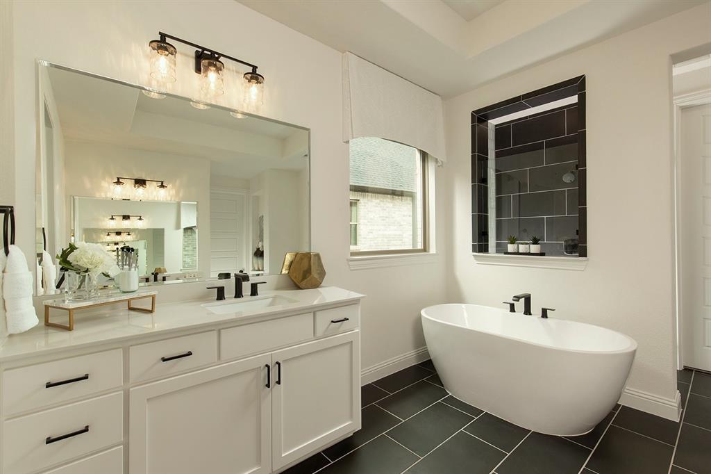 a bathroom with a double vanity sink mirror and bathtub