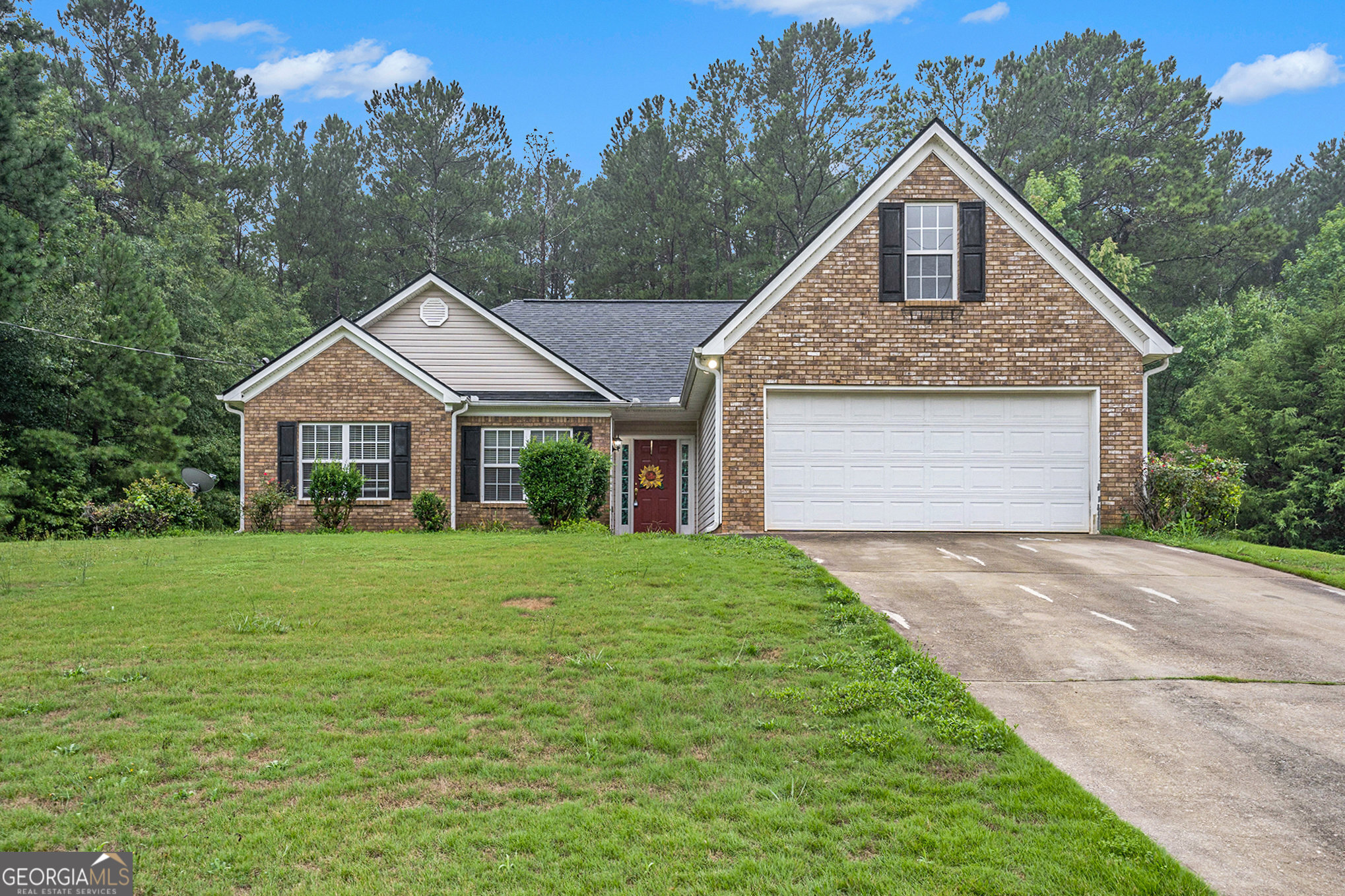 a front view of a house with a yard and trees