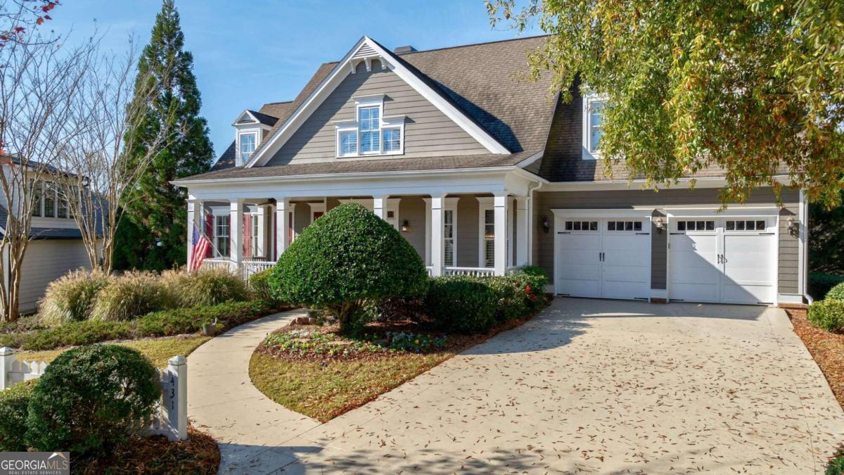 a front view of a house with a yard and potted plants