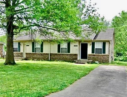 a front view of a house with a yard and trees