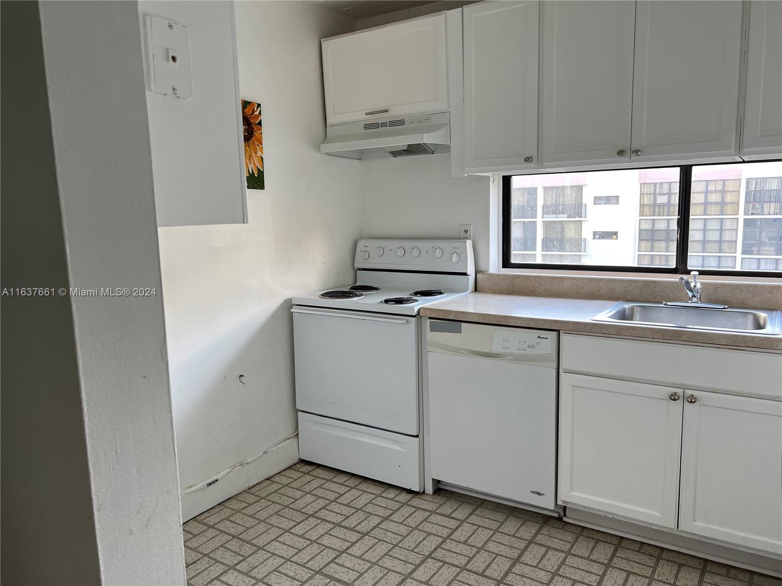 a kitchen with granite countertop white cabinets and white appliances