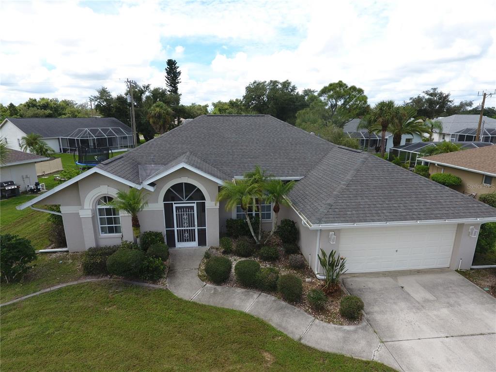 a aerial view of a house with a yard plants and large tree