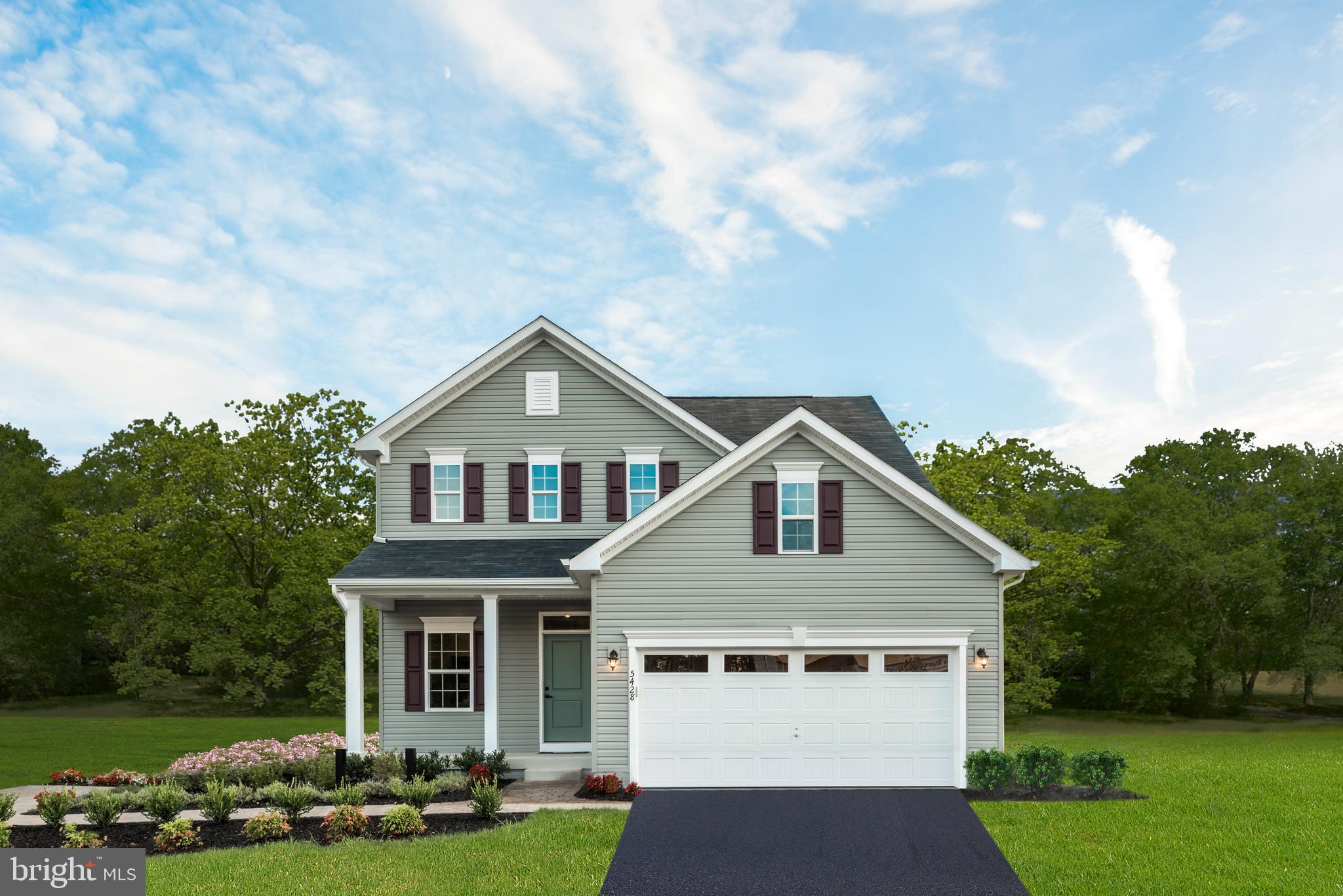 a front view of a house with a yard and trees