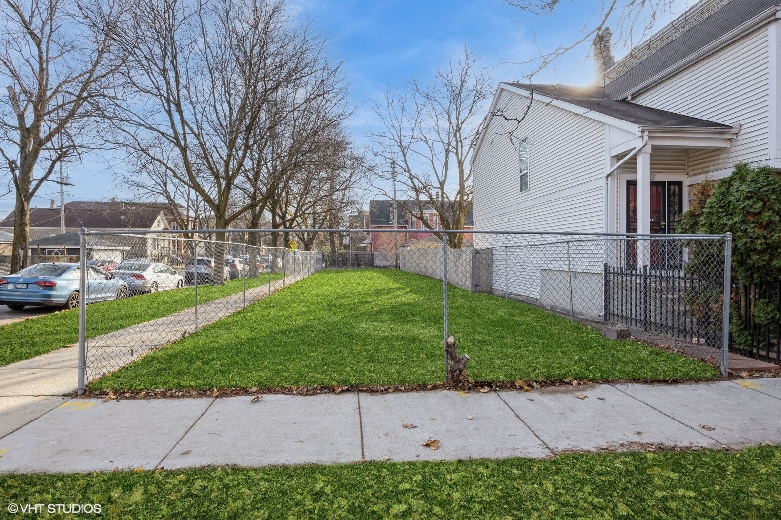 a backyard of a house with plants and large tree