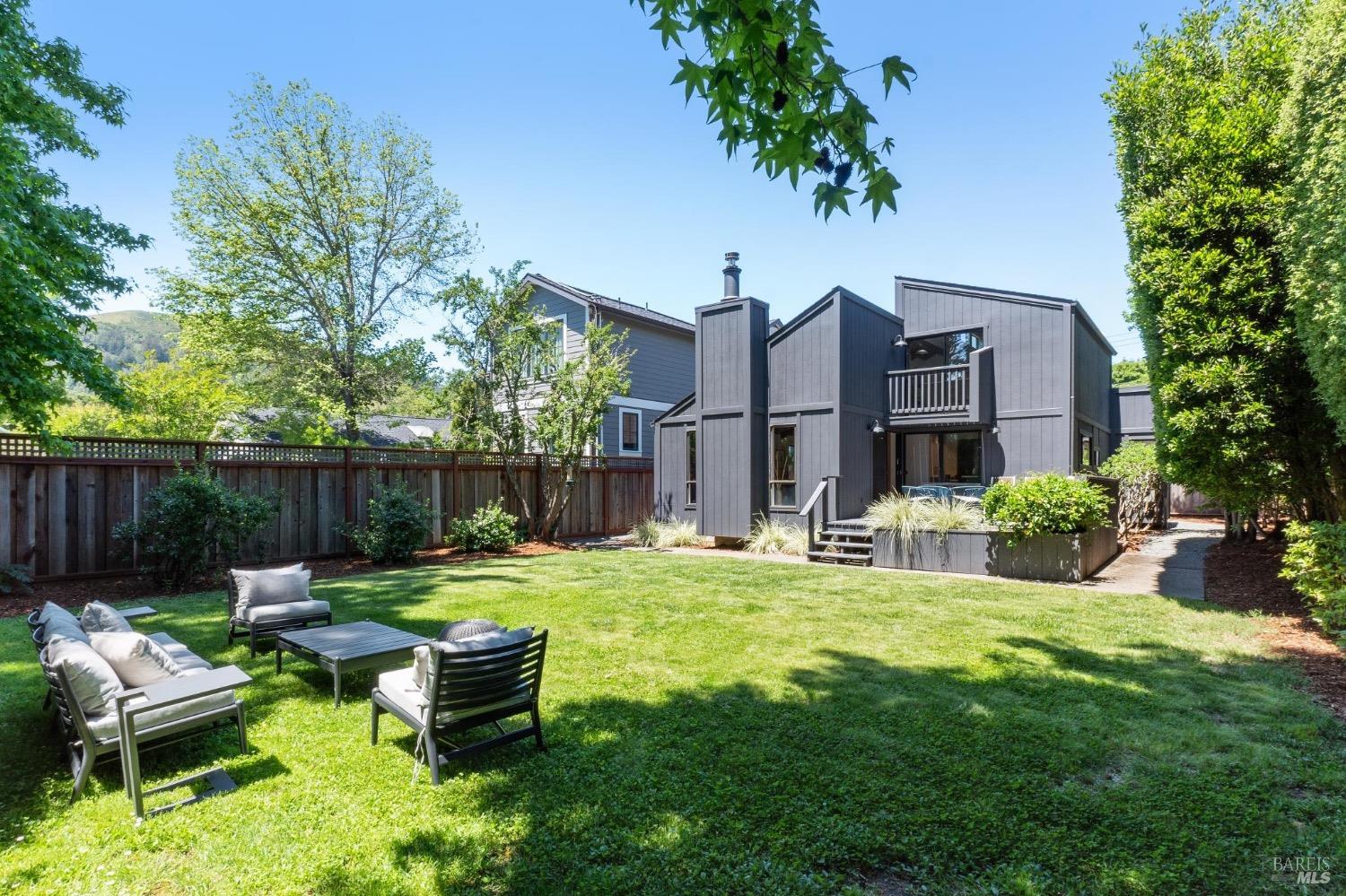 a backyard of a house with table and chairs