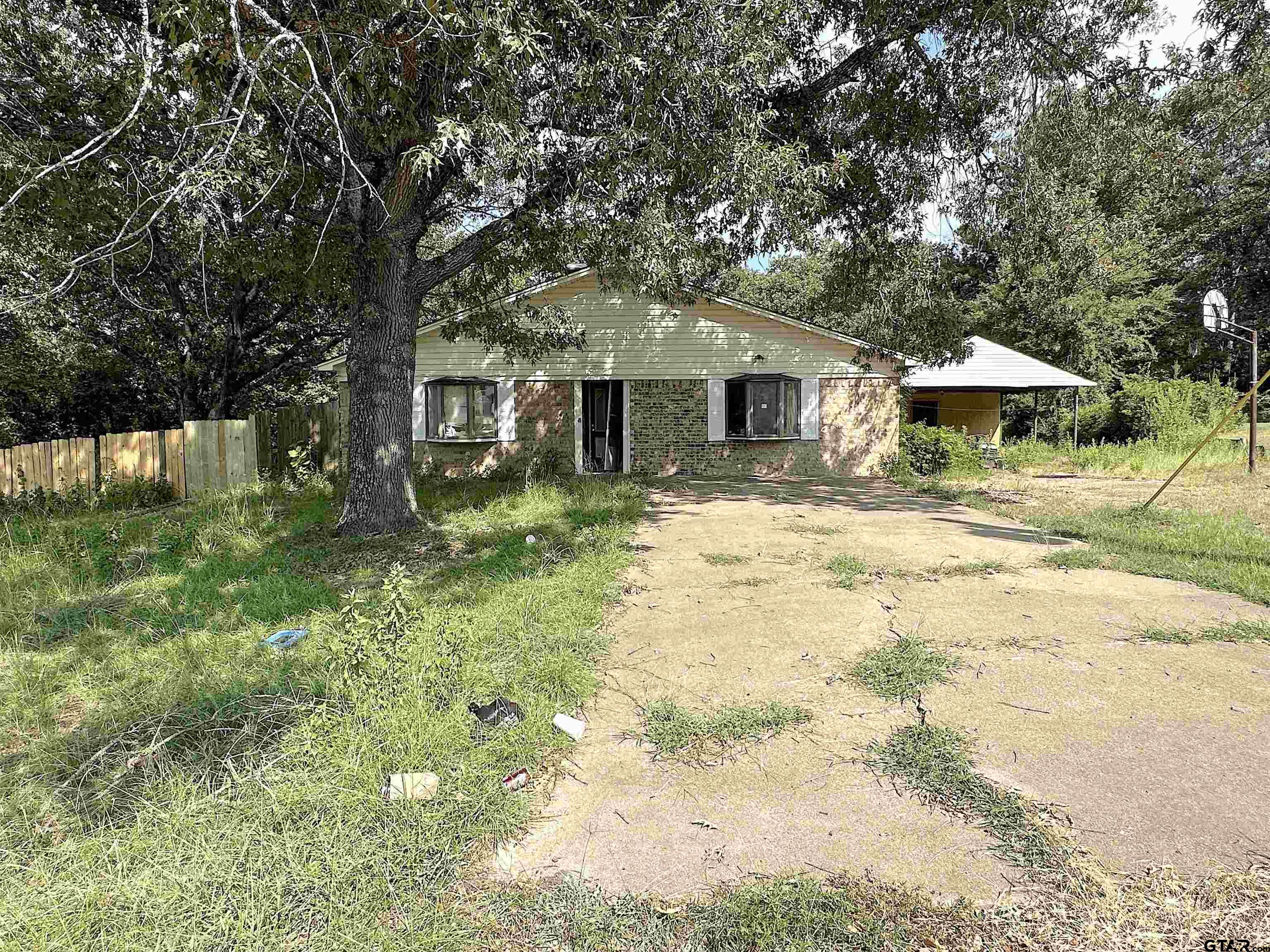 a front view of house with yard and trees around