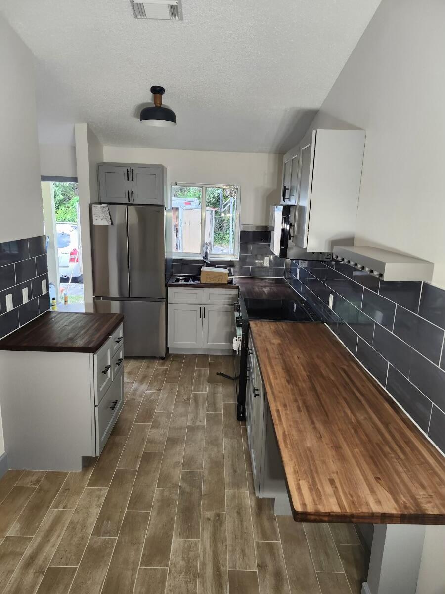 a kitchen with a sink a counter top space stainless steel appliances and cabinets