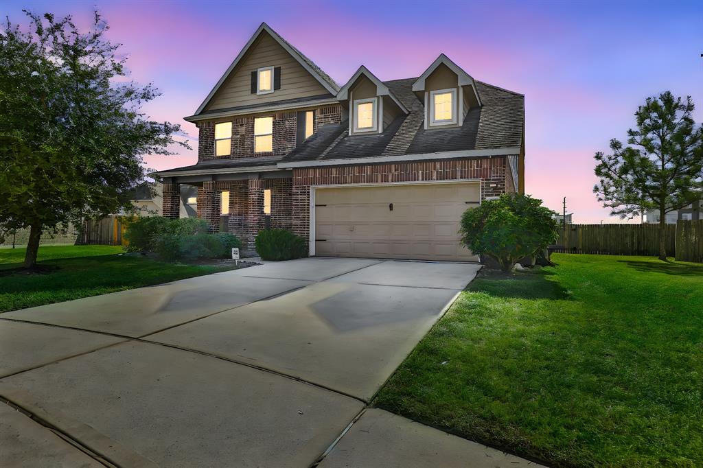 This is a two-story home featuring a brick facade with siding accents, and a two-car garage.