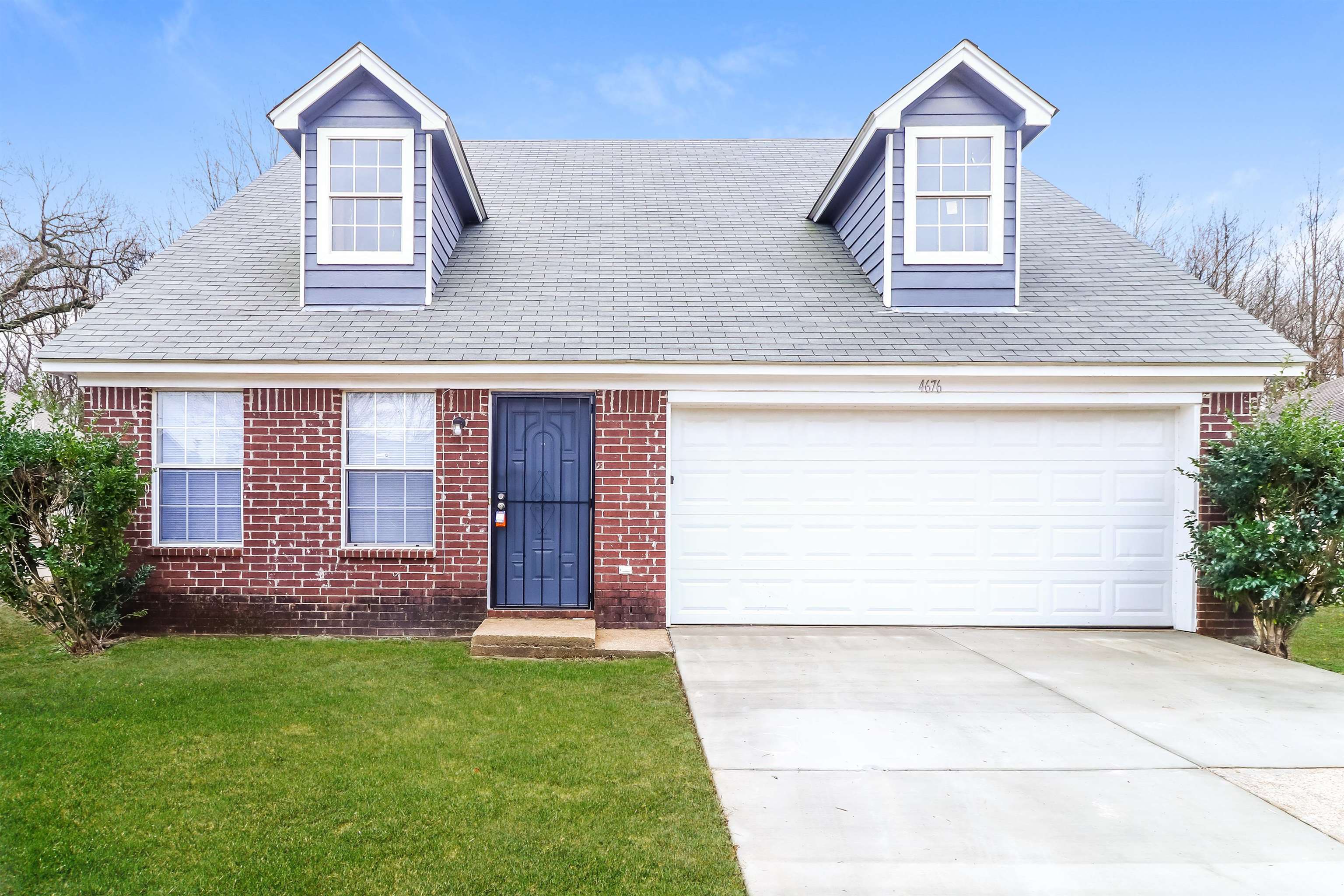 Cape cod house featuring a garage and a front lawn