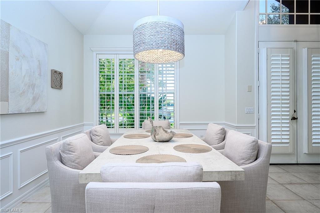 a dining room with furniture and a large window