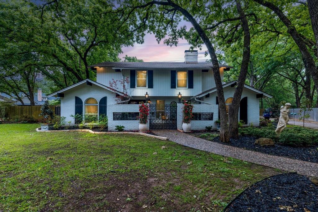 a front view of a house with a yard and trees