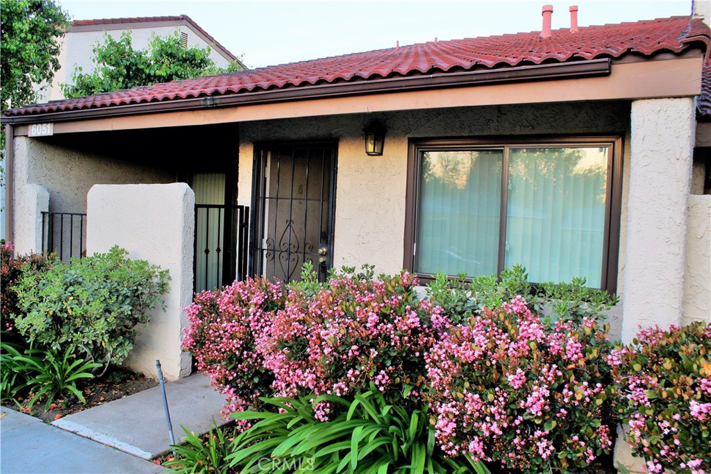 a front view of a house with a lot of flowers