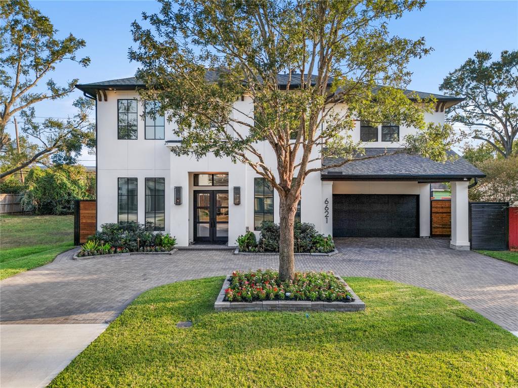 This elegant two-story white stucco home exudes timeless curb appeal, featuring oversized windows that allow for ample natural light. The property boasts a circular paved driveway, enhancing both function and style, while a covered carport provides convenient parking. With no culvert and abundant parking space, this home offers a rare and highly sought-after advantage in the neighborhood. Its sophisticated design and practical layout make it an inviting and desirable residence.