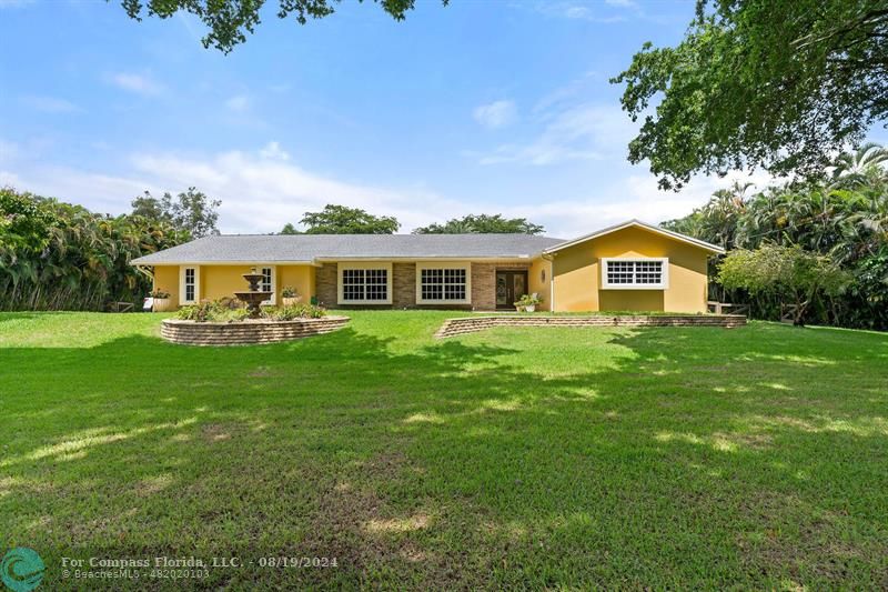 a front view of house with yard and green space