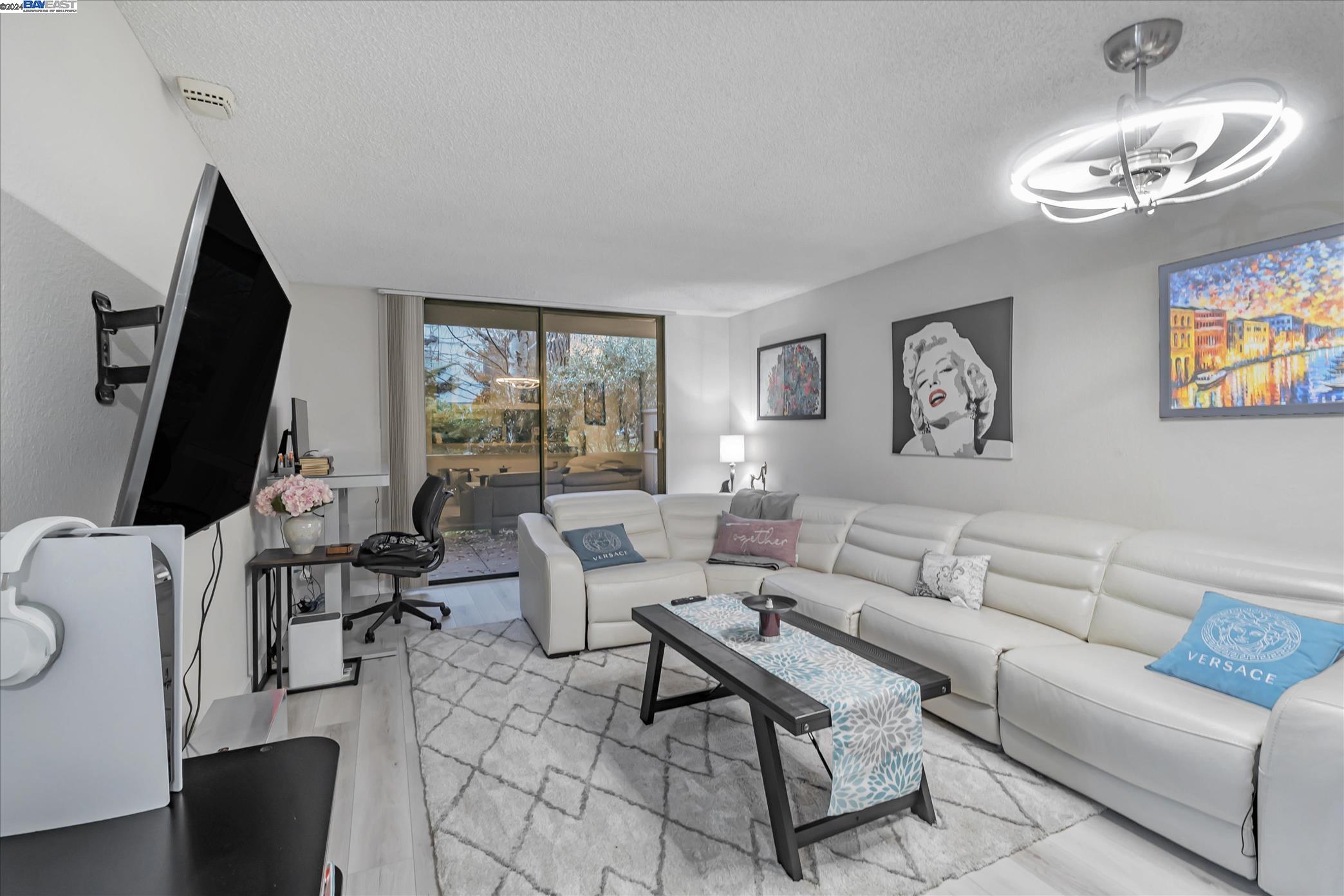 a living room with furniture a large window and a flat screen tv