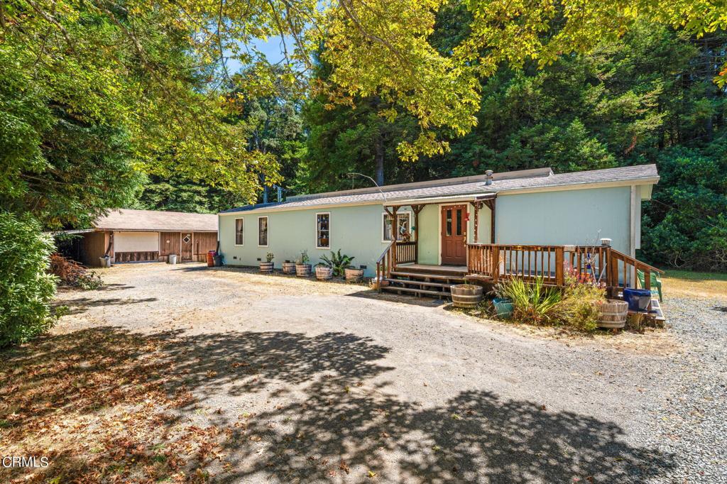 a view of a house with backyard and trees in the background