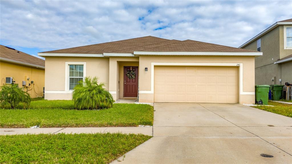 a front view of a house with a yard and garage