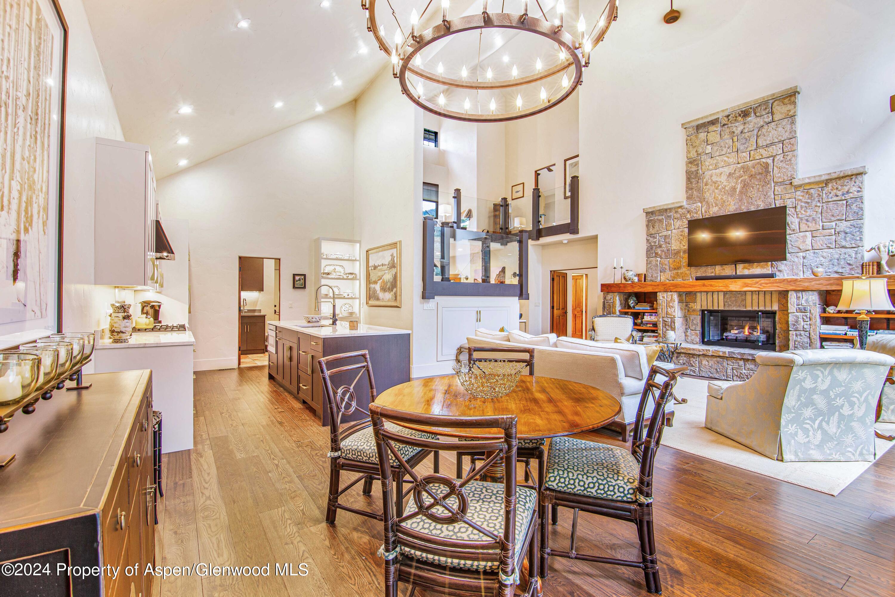 a view of a dining room with furniture a kitchen and chandelier