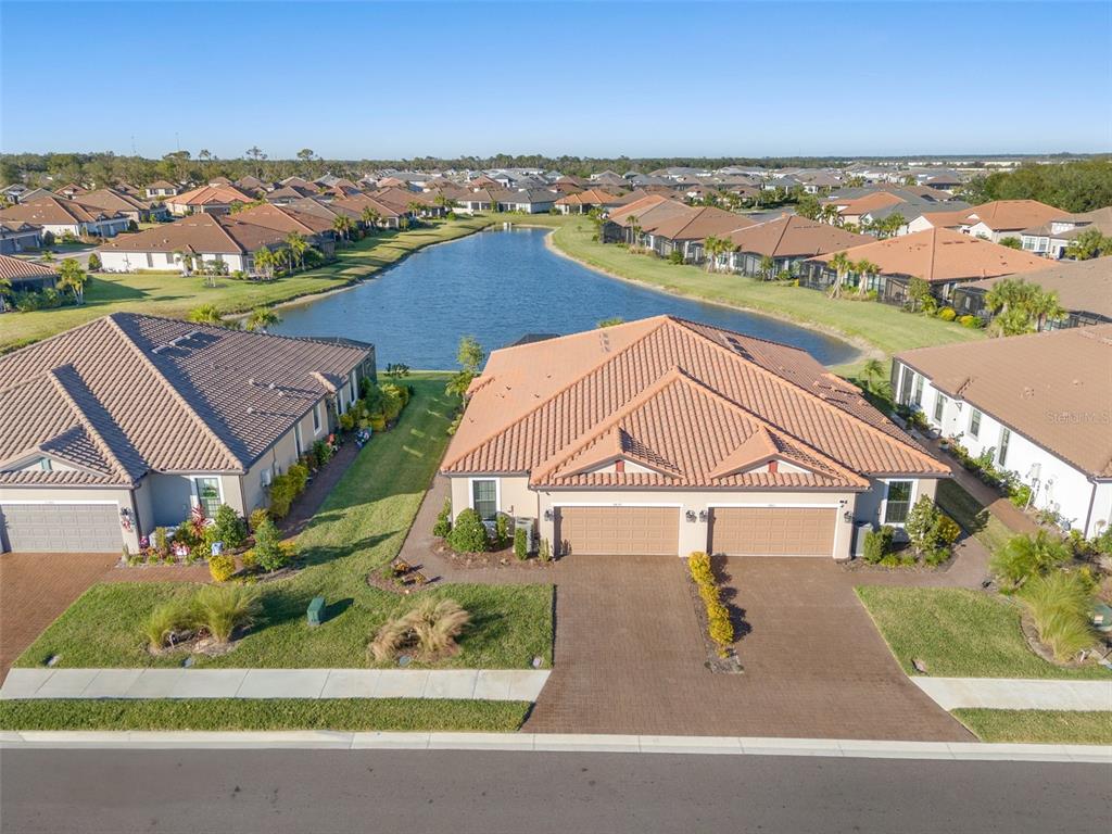 an aerial view of residential houses with outdoor space and ocean view