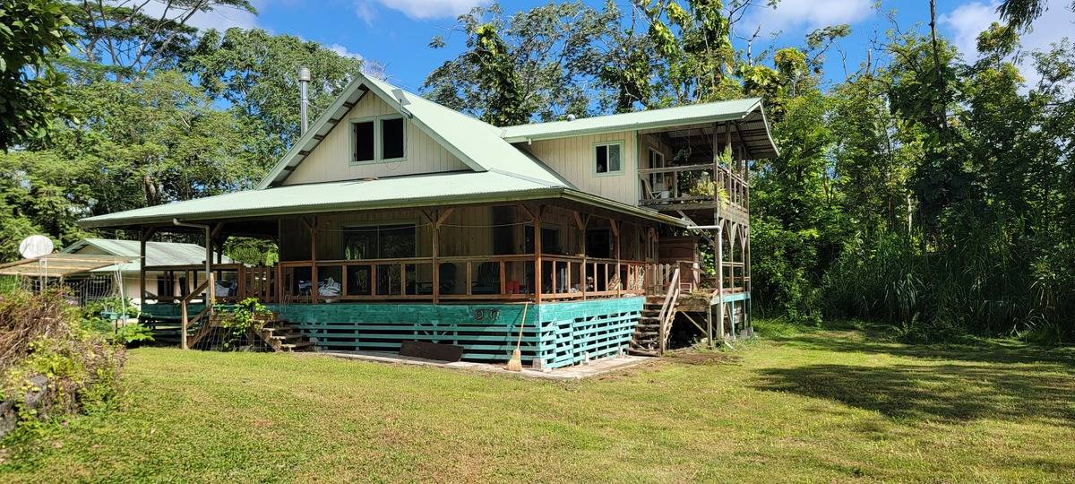 a view of a house with a yard and sitting area