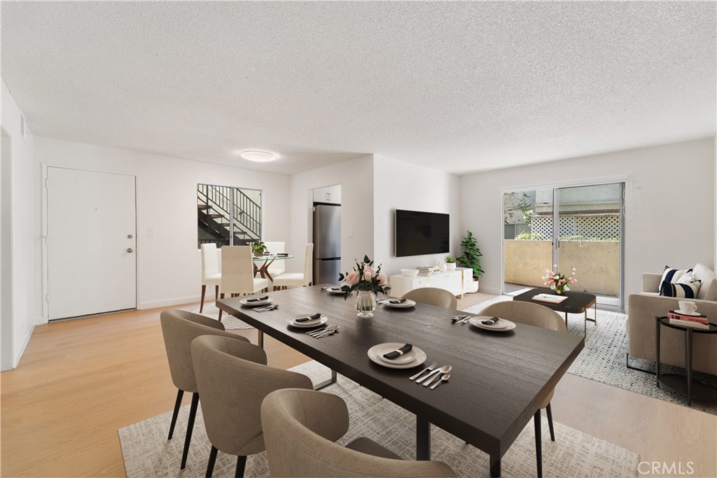 a view of a dining room and livingroom with furniture wooden floor a rug and a chandelier