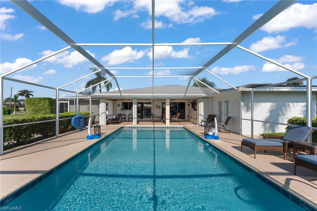 a view of a backyard with a swimming pool and furniture