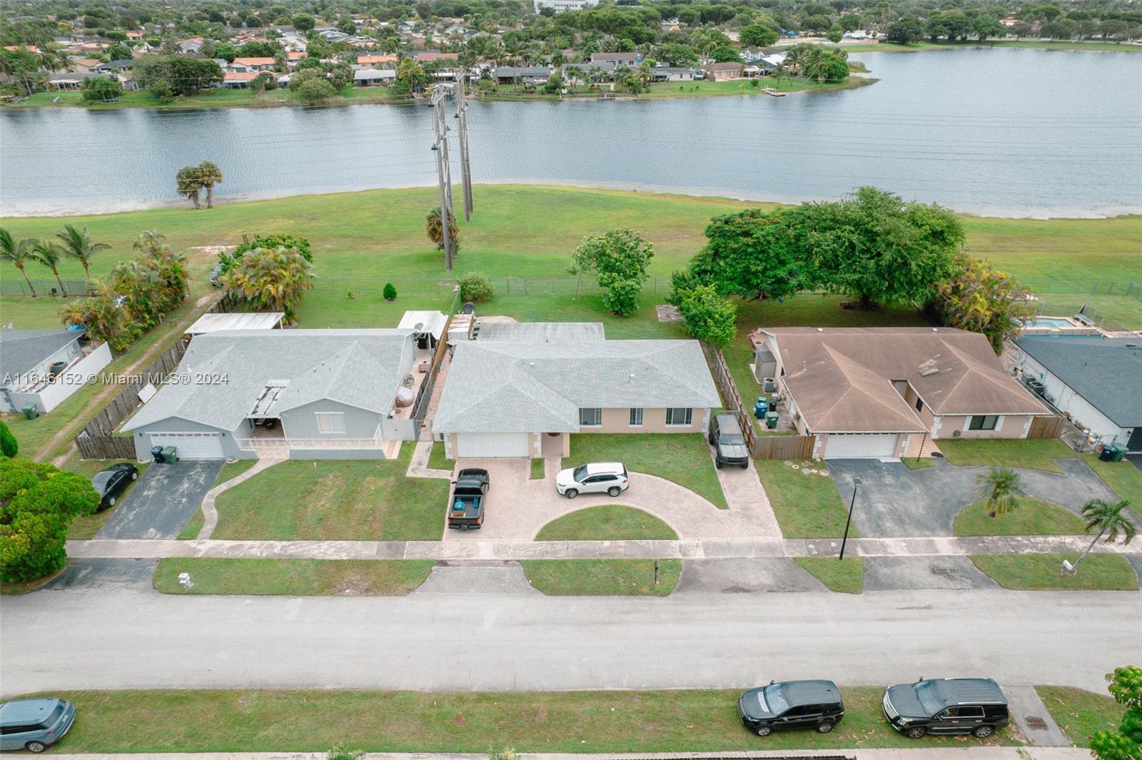 an aerial view of residential houses with outdoor space and lake view