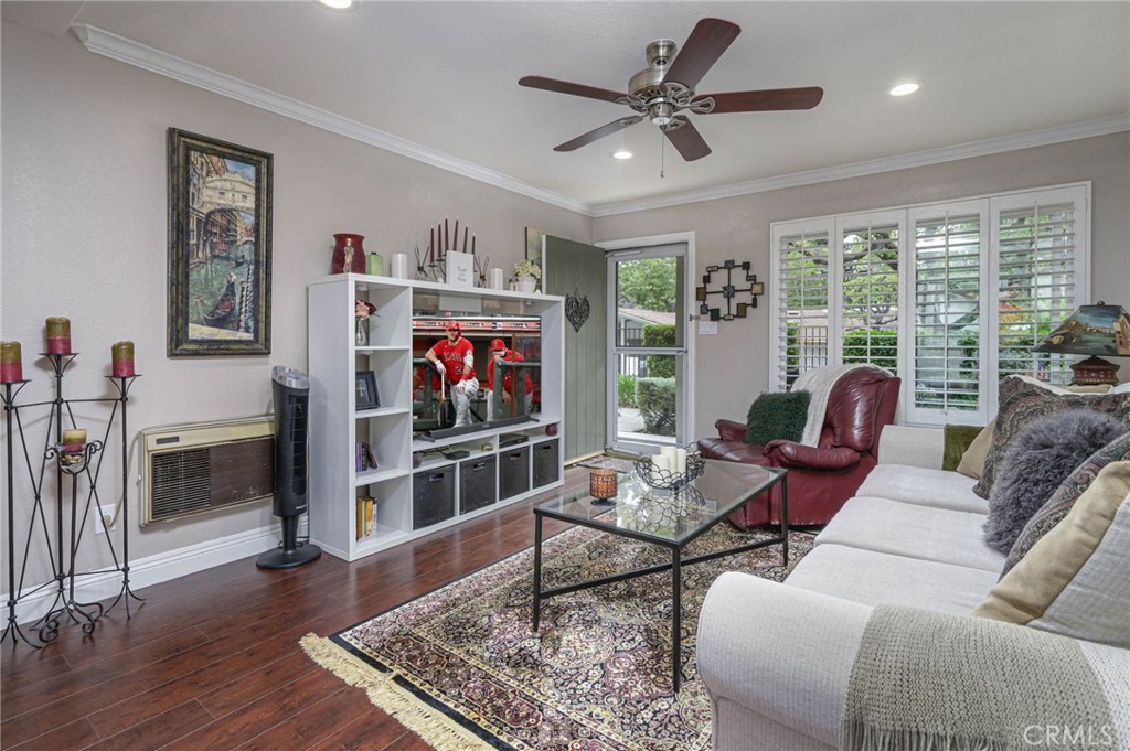 a living room with furniture a flat screen tv and a floor to ceiling window