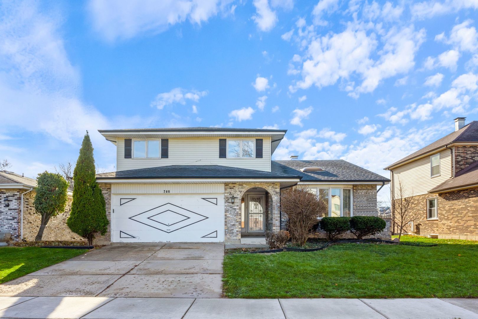 a front view of a house with a yard and garage