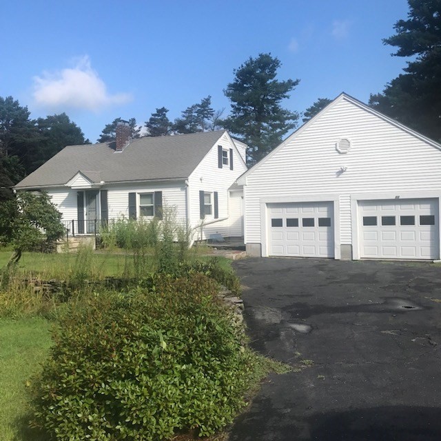 a view of a white house next to a yard