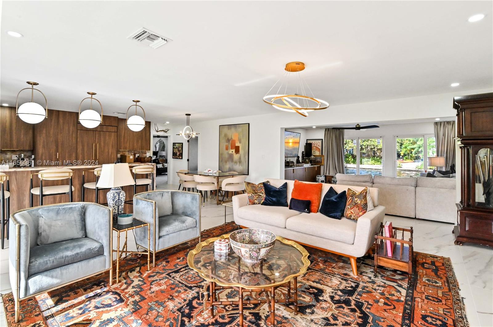 a living room with furniture kitchen view and a large window