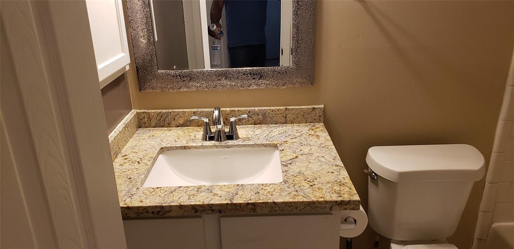 a bathroom with a granite countertop sink and a mirror