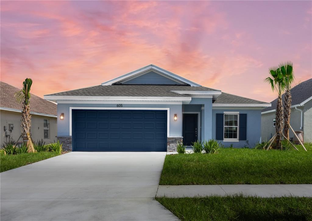 a front view of a house with a yard and garage