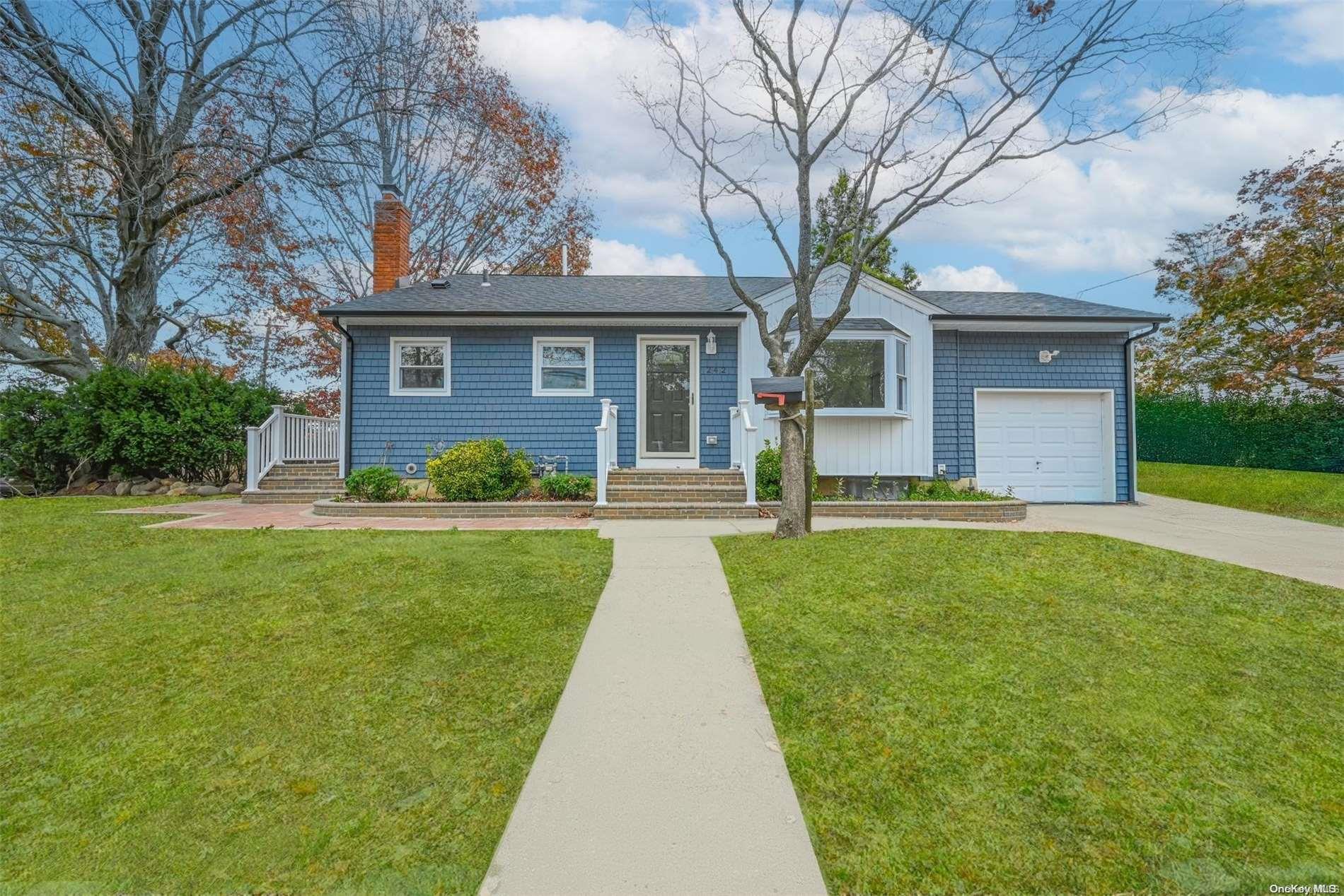 a front view of a house with a yard and trees