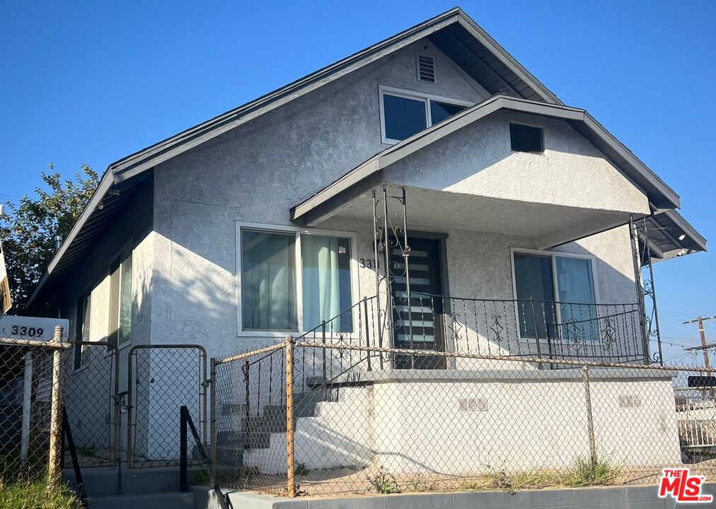 a view of a house with a wooden bench