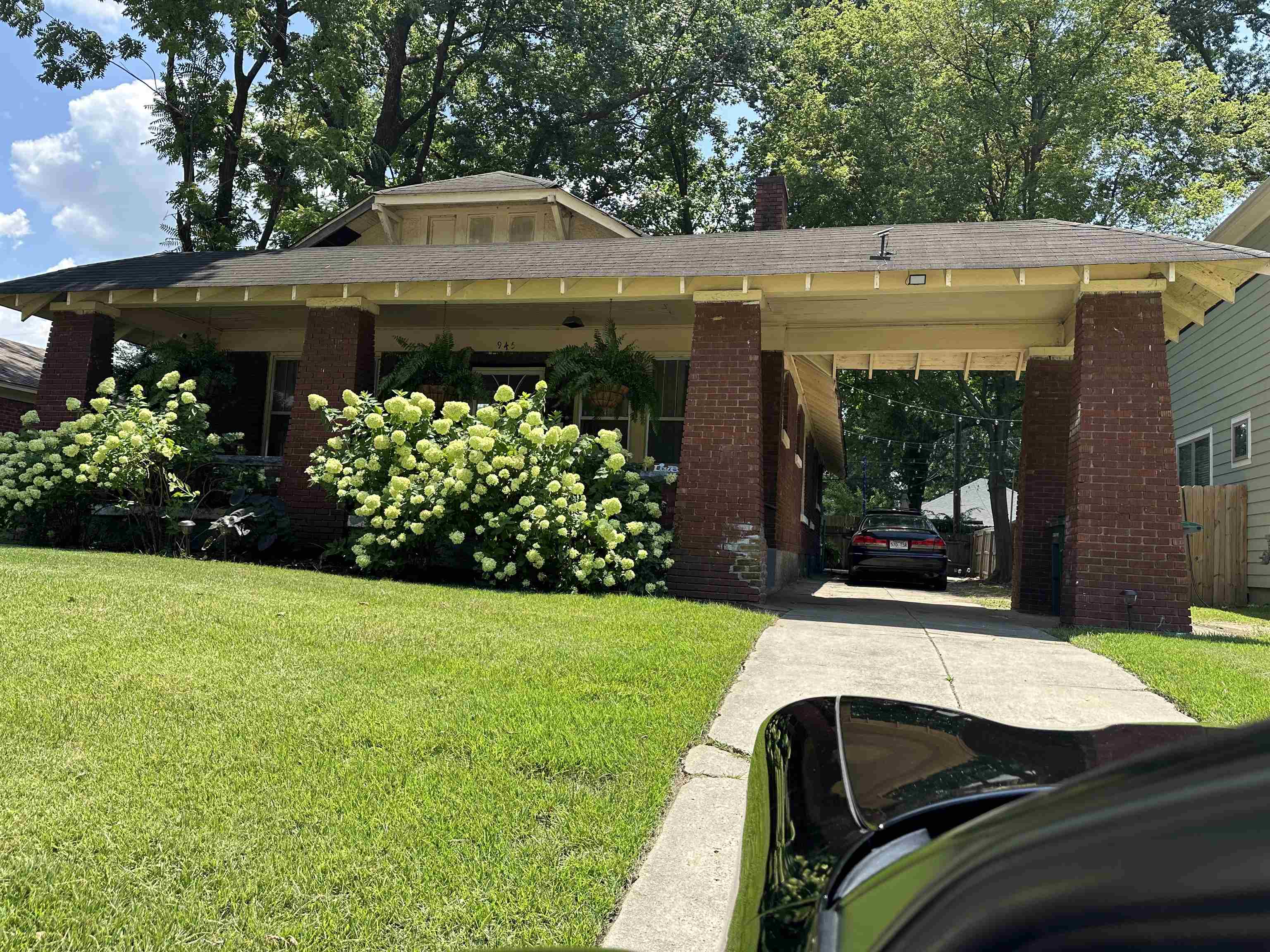 View of front facade featuring a carport and a front yard