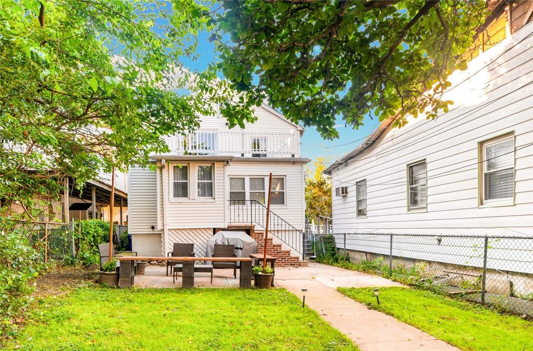 a view of a house with a backyard and chairs