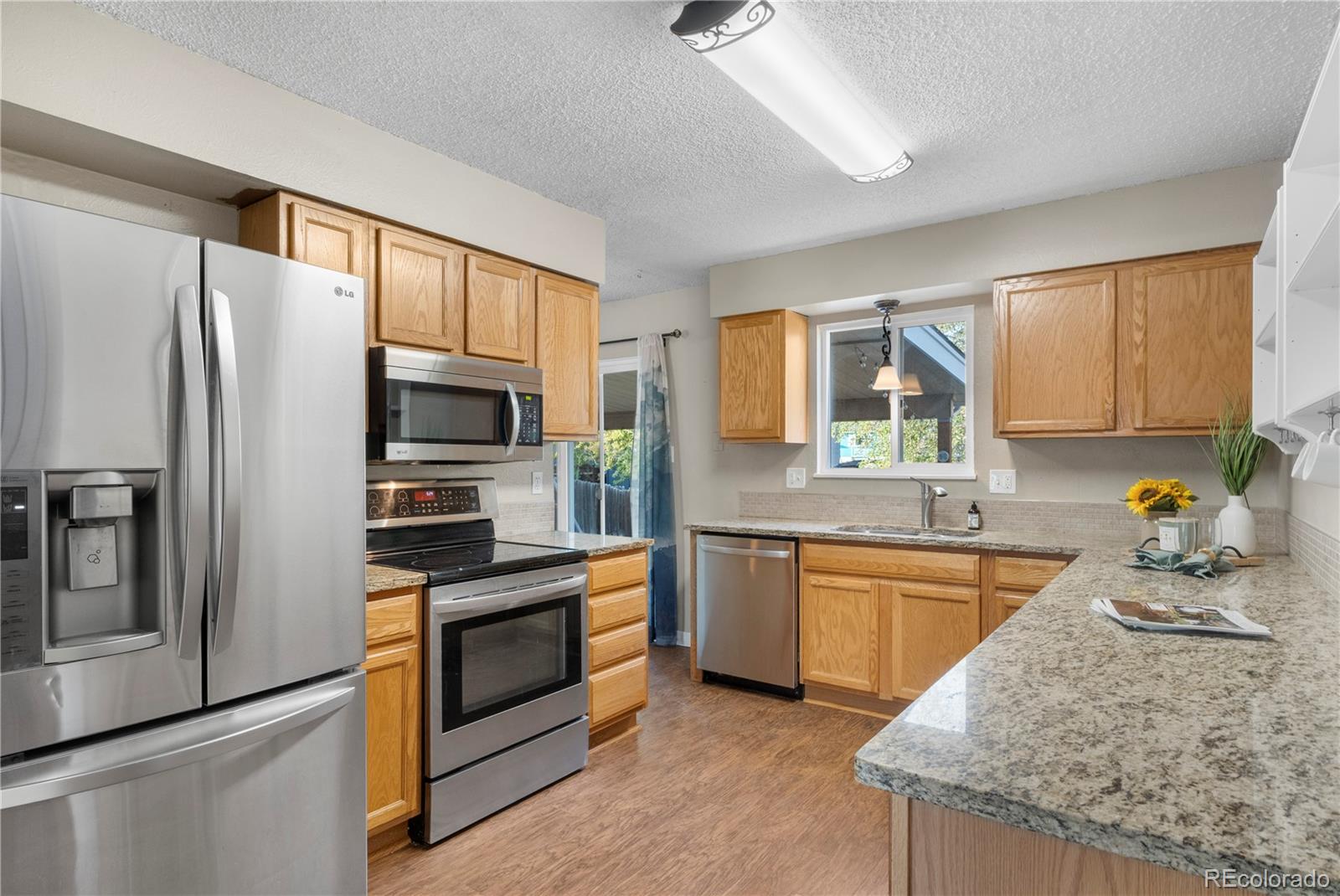 a kitchen with stainless steel appliances granite countertop a refrigerator stove and sink